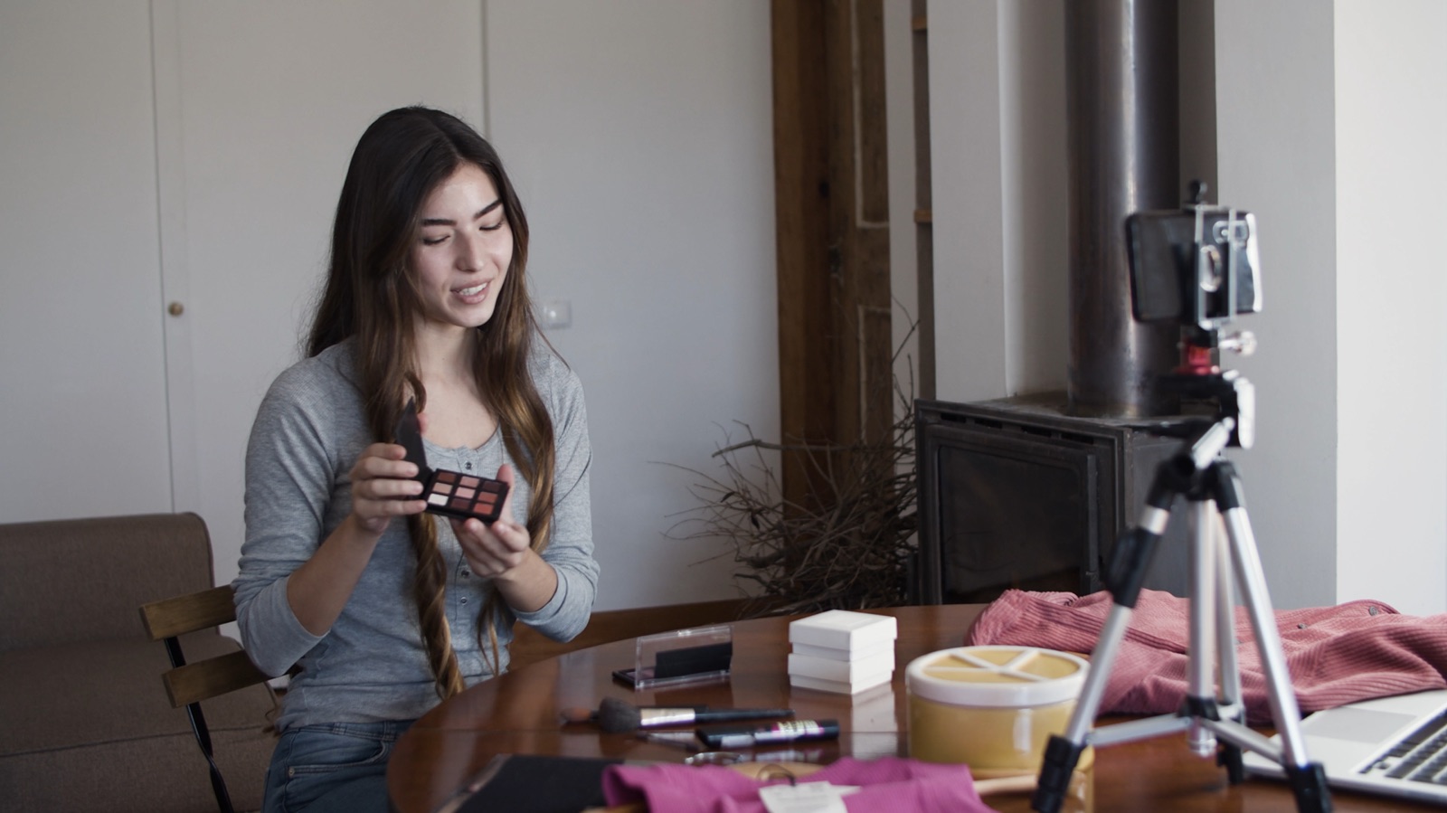 Creator filming a product video on a phone tripod at her desk